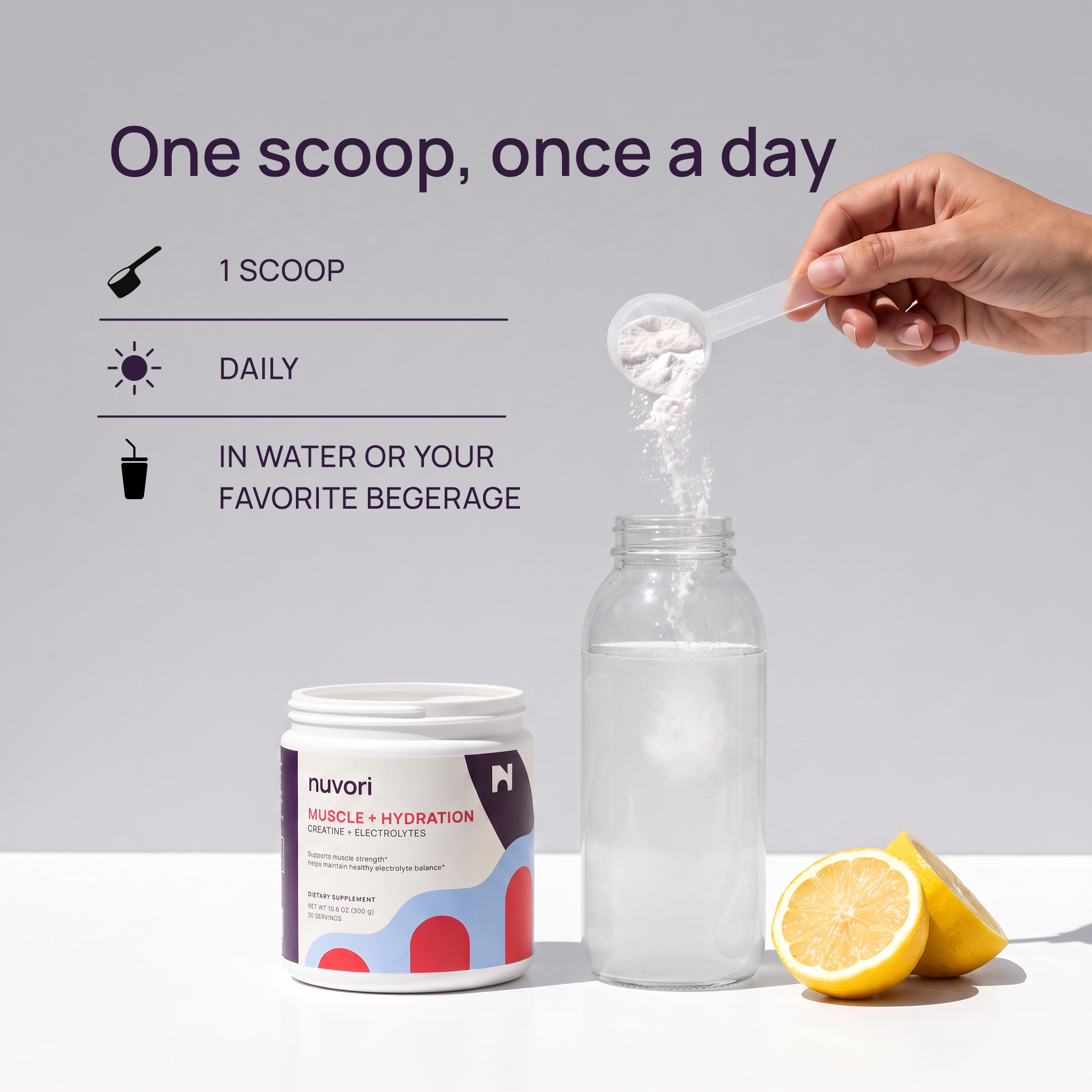 A hand holds a scoop of white powder above a clear bottle, with a jar of Nuvori Muscle + Hydration drink mix and lemon slices on a white surface. Text on the left reads: 'One scoop, once a day' with icons for 1 scoop, daily use, and in water or favorite beverage.